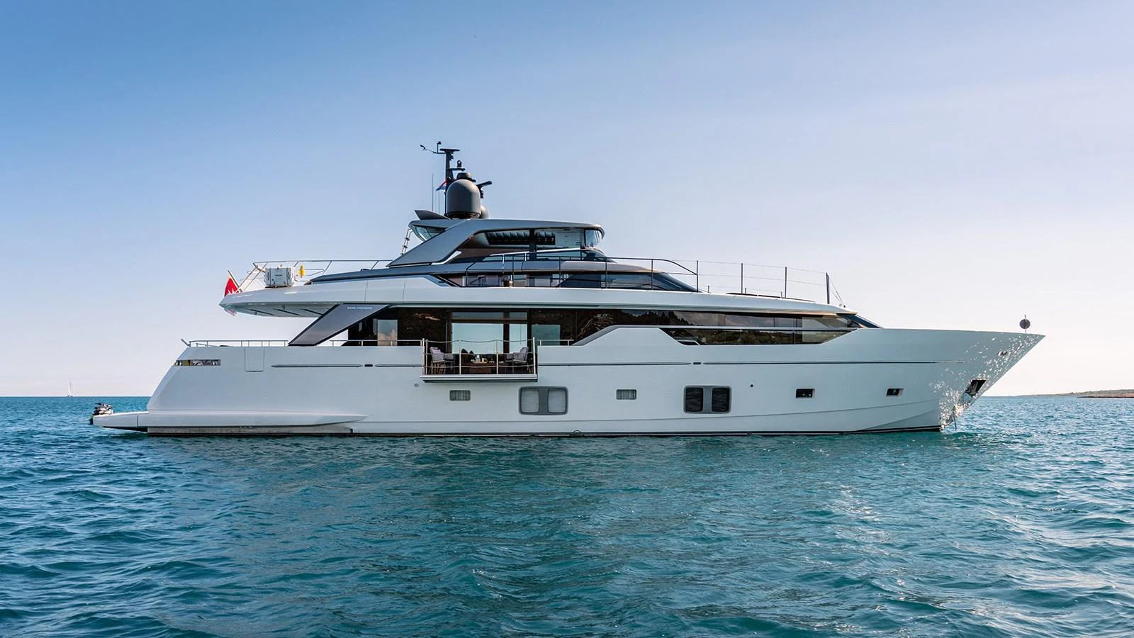 A sleek and modern yacht cruising on calm blue waters under a clear sky. aboard JOURNEY Yacht for Sale