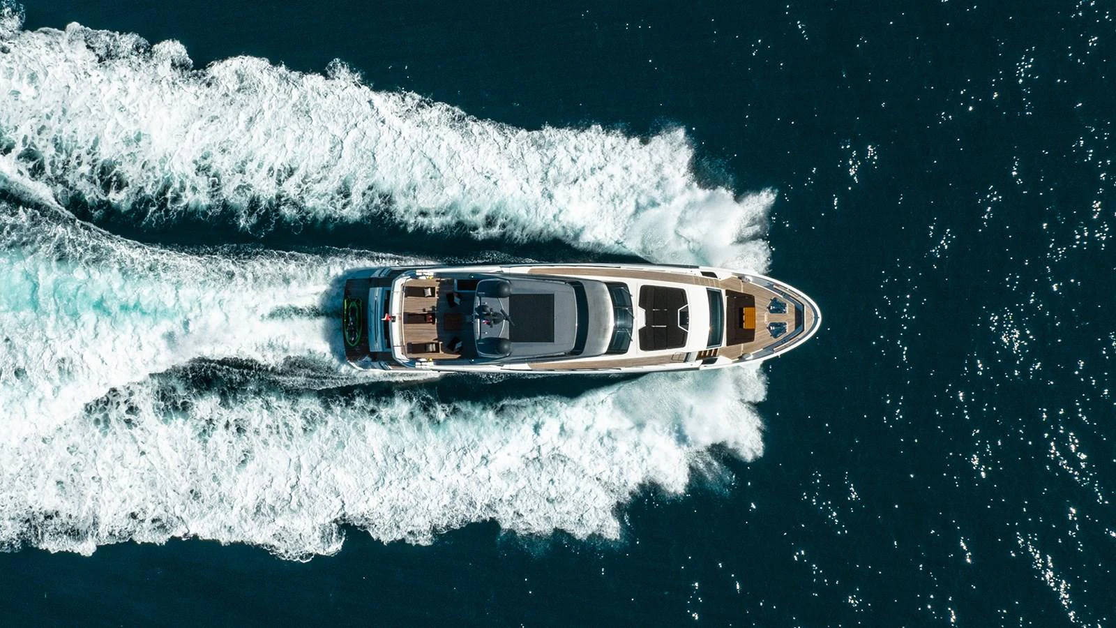 A stunning aerial view of a yacht cruising through the water, leaving a beautiful wake behind. aboard JOURNEY Yacht for Sale