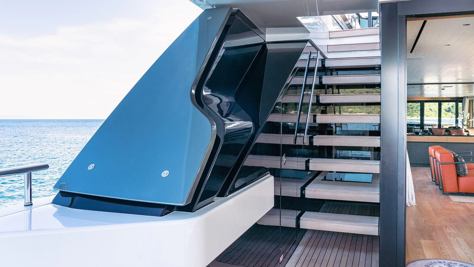 The yacht's aft deck features a sleek staircase leading to the upper level, with a view of the ocean in the background. aboard JOURNEY Yacht for Sale