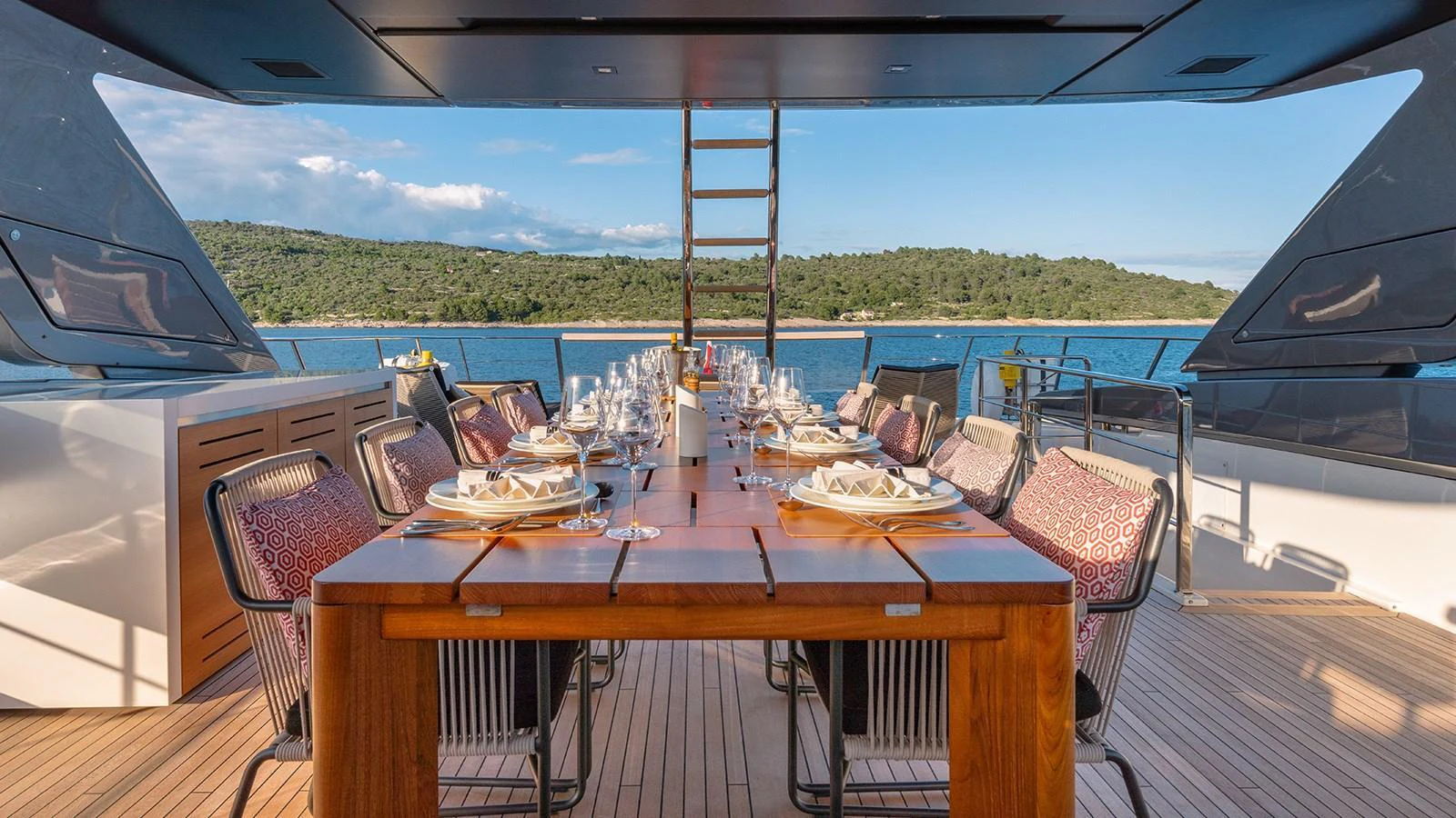 The aft deck features an elegant dining area with a stunning view of the sea. aboard JOURNEY Yacht for Sale
