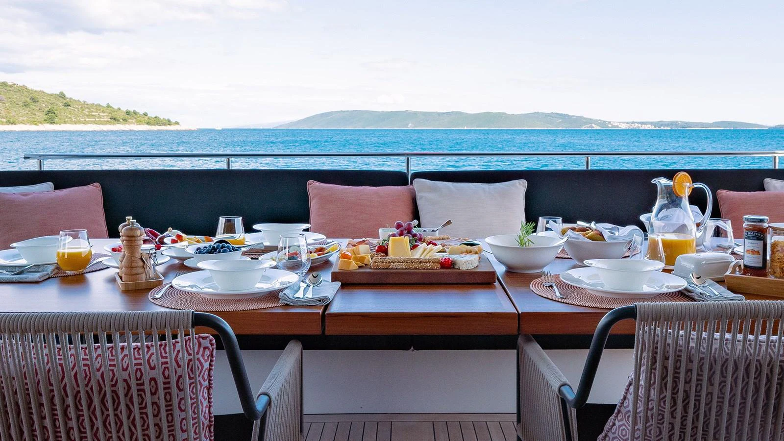 An inviting alfresco dining area set for a meal with a stunning ocean view. aboard JOURNEY Yacht for Sale