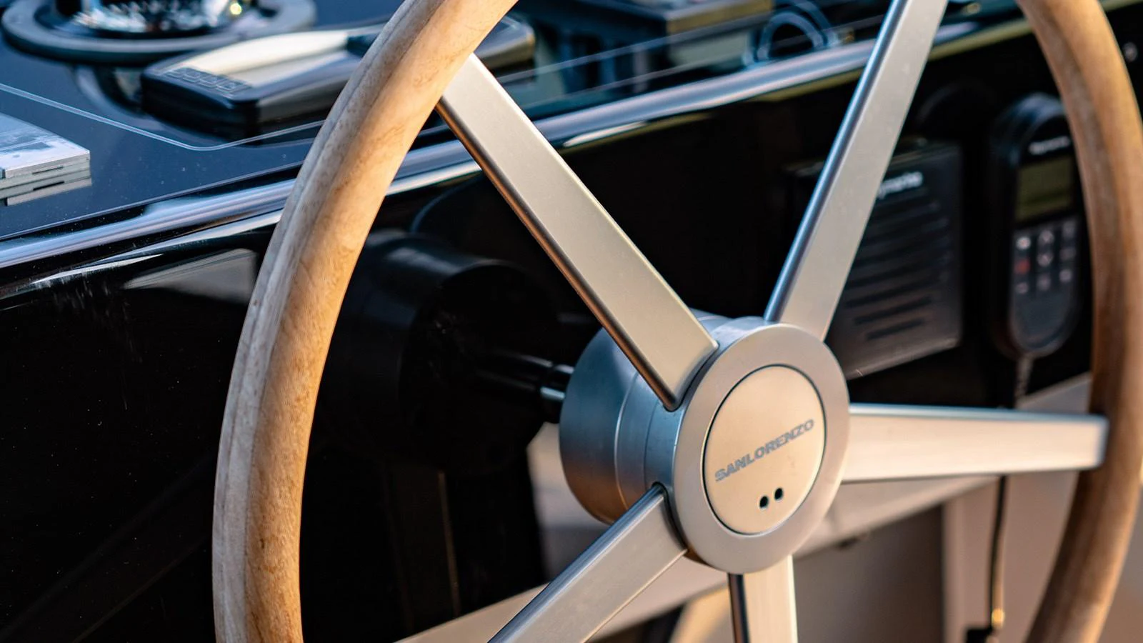 A close-up of the yacht's helm showcasing a sleek steering wheel and control panel. aboard JOURNEY Yacht for Sale