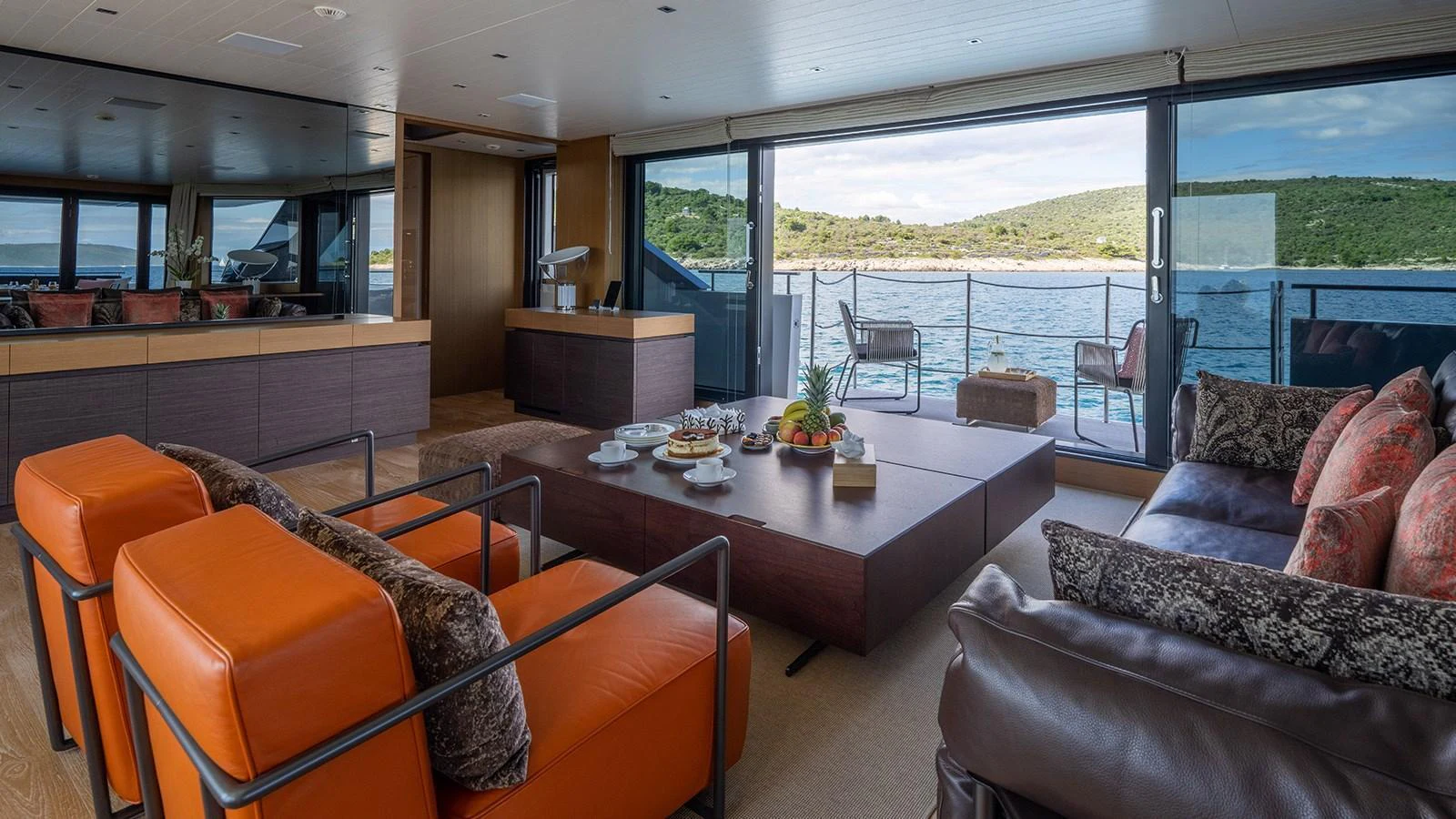 The salon features comfortable seating with a stunning view of the water through large windows. aboard JOURNEY Yacht for Sale