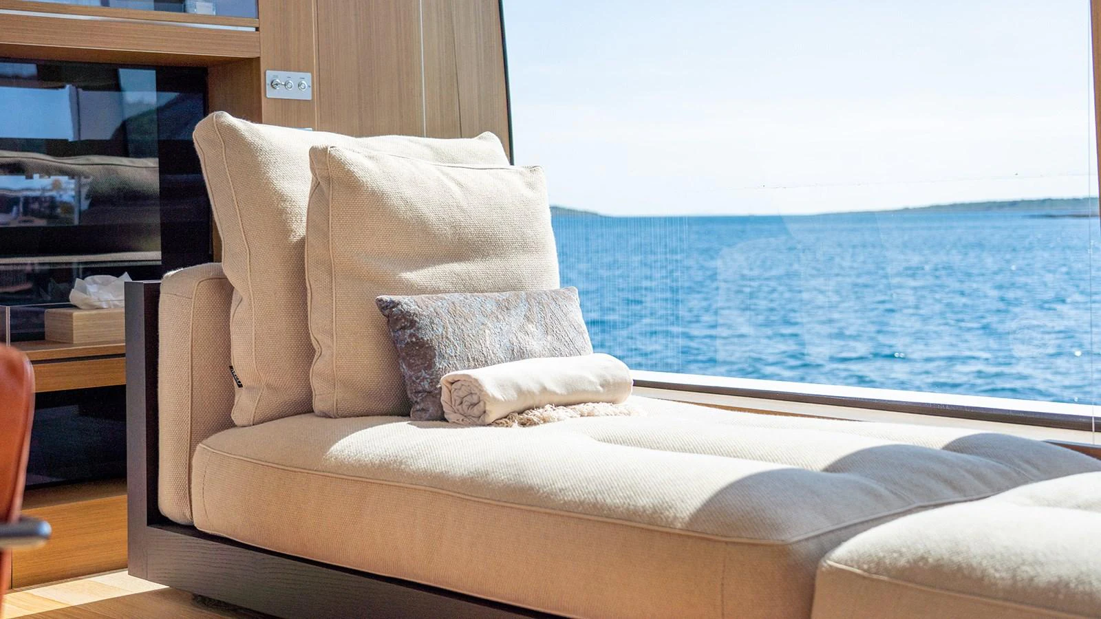 A luxurious interior lounge area with a plush chaise longue and a stunning sea view. aboard JOURNEY Yacht for Sale
