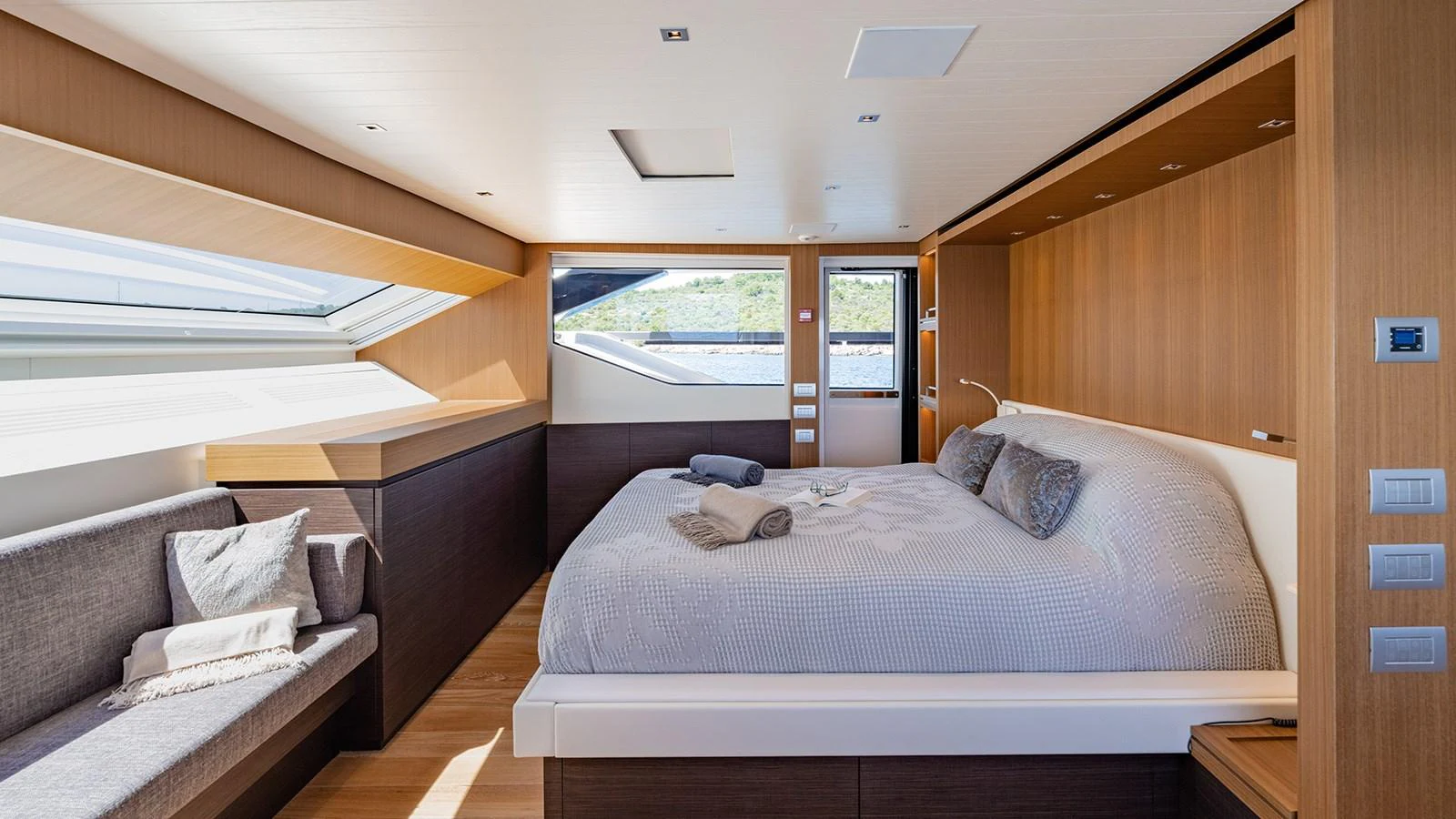 The master stateroom features a luxurious bed, ample natural light, and elegant wood finishes. aboard JOURNEY Yacht for Sale
