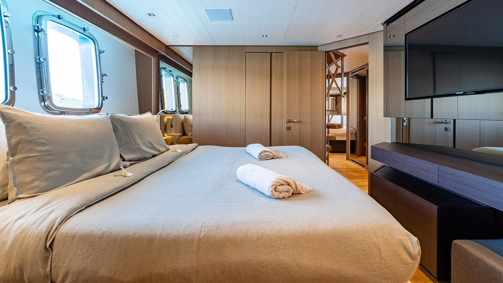 The master stateroom features a spacious bed with luxurious linens and ample natural light from large windows. aboard JOURNEY Yacht for Sale