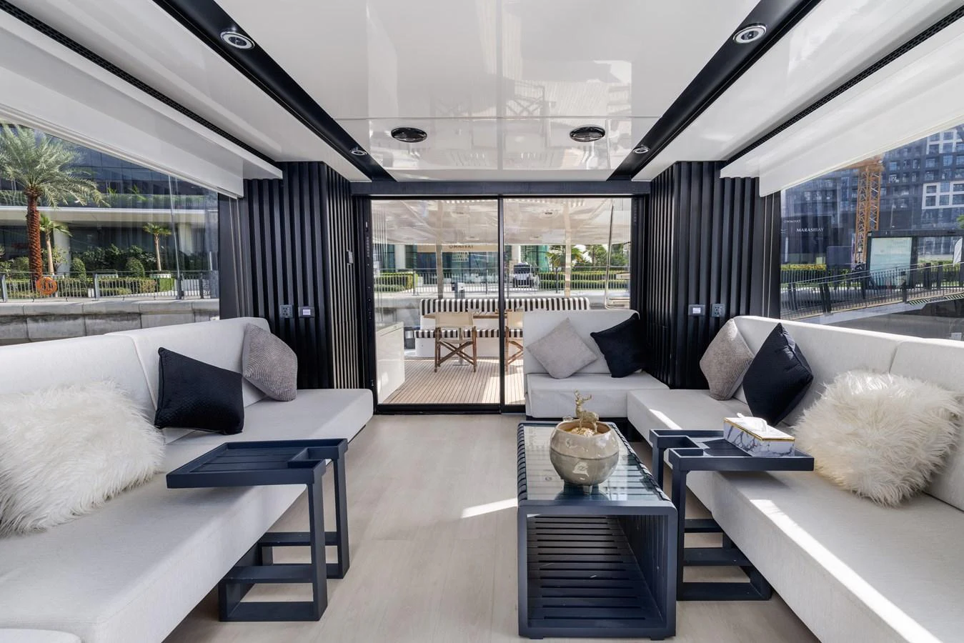 The yacht's interior lounge area features modern decor with comfortable seating and a view of the exterior through large glass doors. aboard AL SULTAN Yacht for Sale