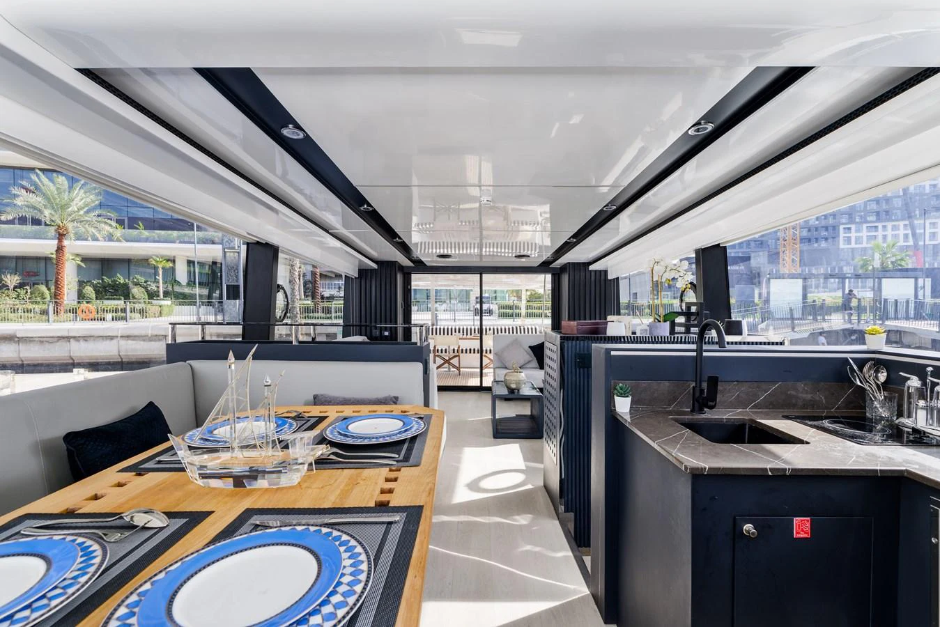 The yacht's dining area features elegant table settings and a modern galley with ample natural light. aboard AL SULTAN Yacht for Sale