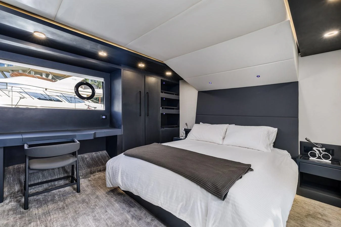 The stateroom features a luxurious bed with modern furnishings and ample natural light. aboard AL SULTAN Yacht for Sale