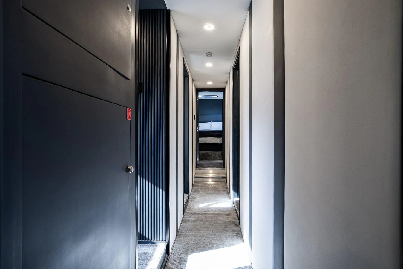 A sleek and modern hallway leading to a stateroom, featuring contemporary design elements and ambient lighting. aboard AL SULTAN Yacht for Sale