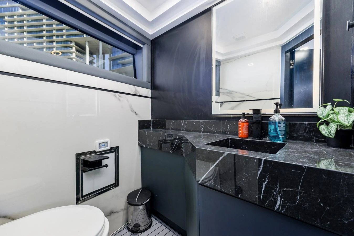 A sleek and modern bathroom with a black marble countertop and stylish fixtures. aboard AL SULTAN Yacht for Sale