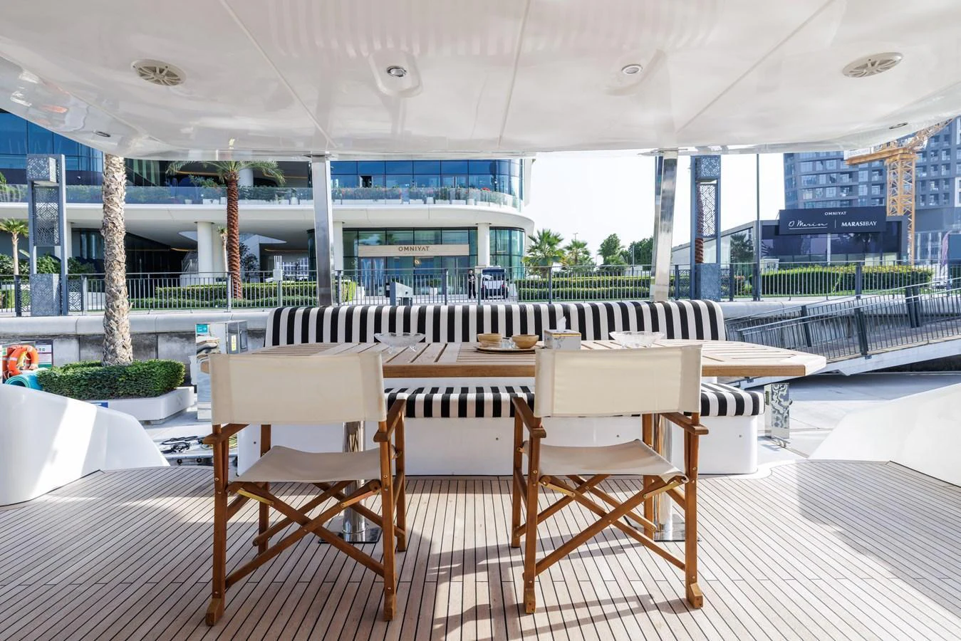 The aft deck features a stylish dining area with comfortable seating and a scenic view. aboard AL SULTAN Yacht for Sale
