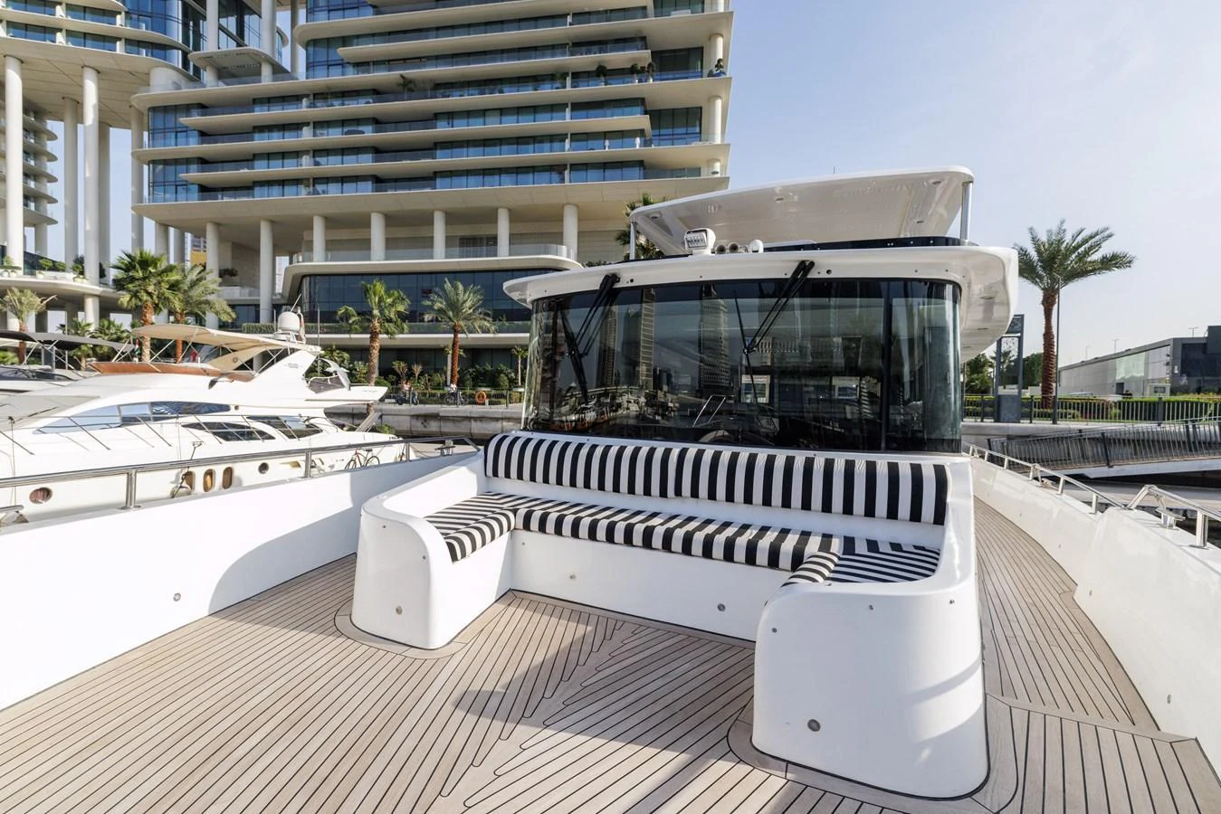 The foredeck features a spacious seating area with striped cushions, perfect for relaxation and socializing. aboard AL SULTAN Yacht for Sale