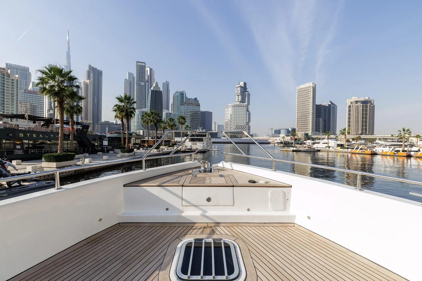 The yacht's foredeck offers a spacious and inviting area with a stunning city skyline in the background. aboard AL SULTAN Yacht for Sale