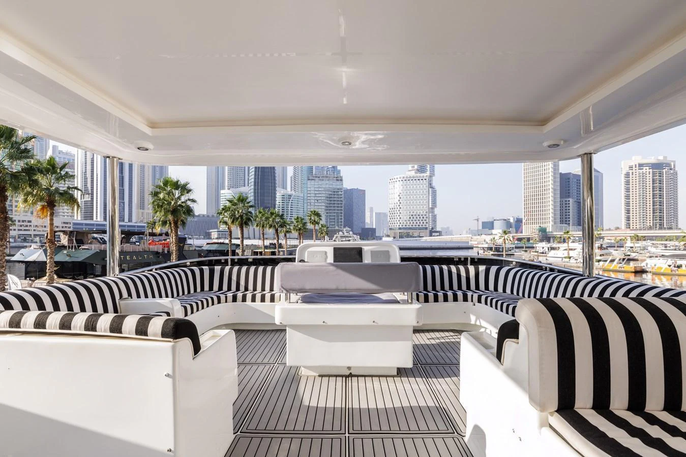 The sundeck features a spacious seating area with striped cushions, perfect for relaxing and enjoying the view. aboard AL SULTAN Yacht for Sale
