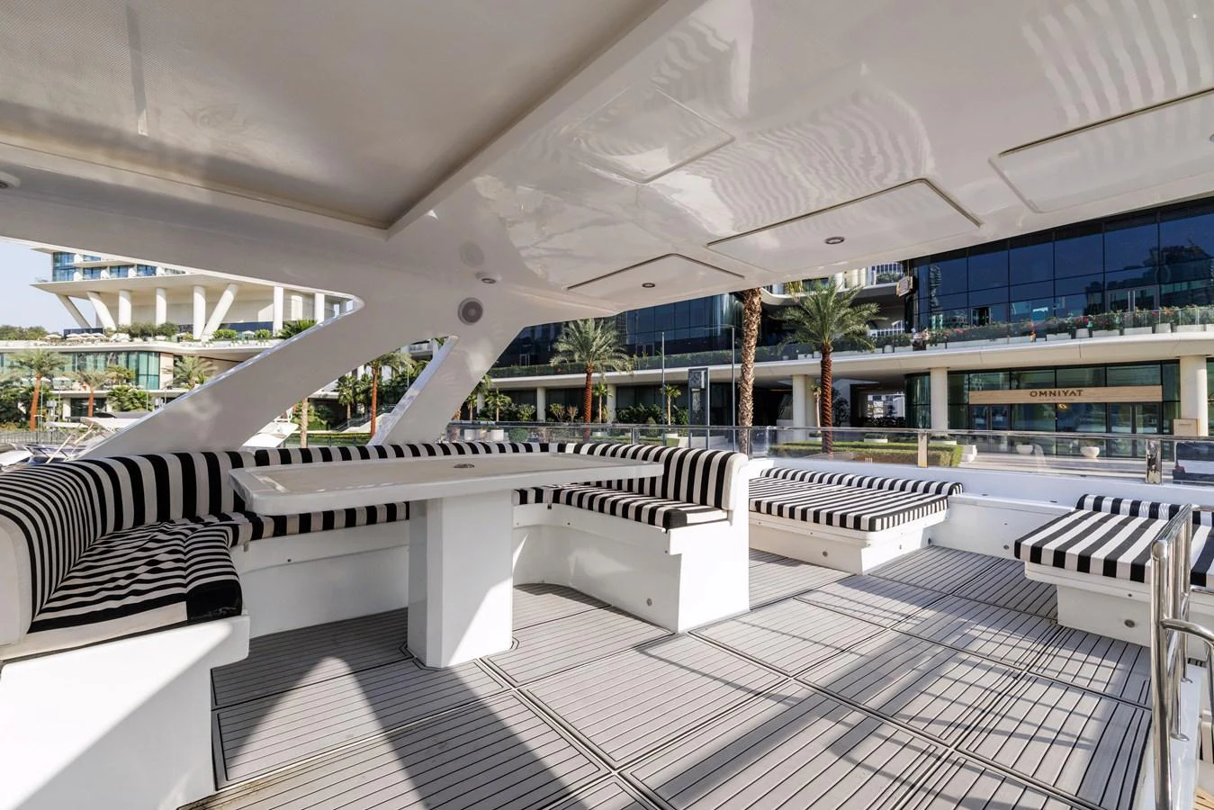 The aft deck features stylish seating with striped cushions, perfect for outdoor relaxation and socializing. aboard AL SULTAN Yacht for Sale