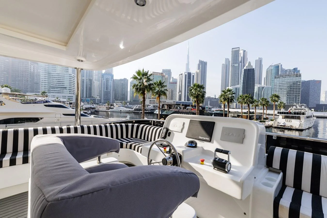 The helm area offers a stylish and comfortable space with a stunning cityscape backdrop. aboard AL SULTAN Yacht for Sale