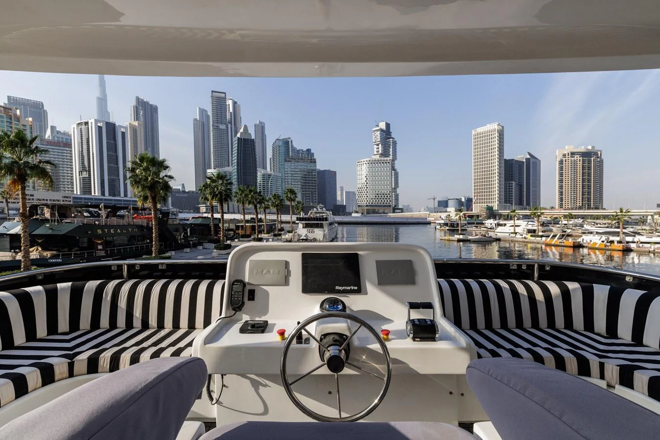 The helm area offers a stunning view of a modern city skyline, blending luxury with urban sophistication. aboard AL SULTAN Yacht for Sale