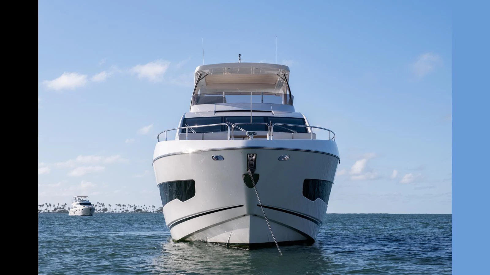 A sleek yacht is anchored on calm waters, showcasing its modern design and spacious upper deck. aboard ONLY 1100 HRS! Yacht for Sale