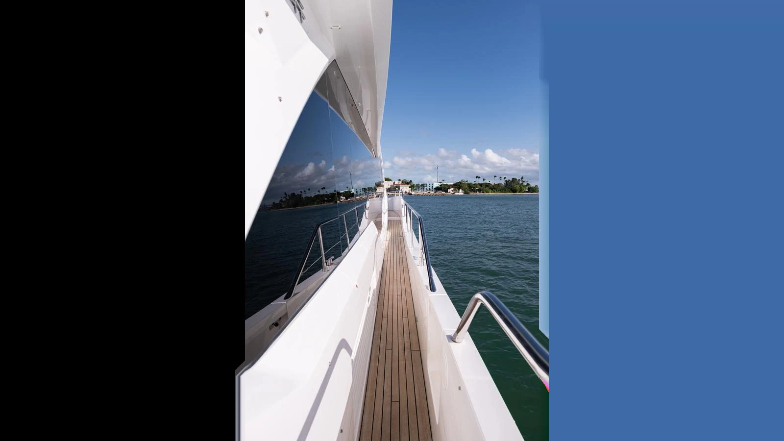 A sleek yacht deck with polished railings and a clear view of the water and distant shoreline. aboard ONLY 1100 HRS! Yacht for Sale