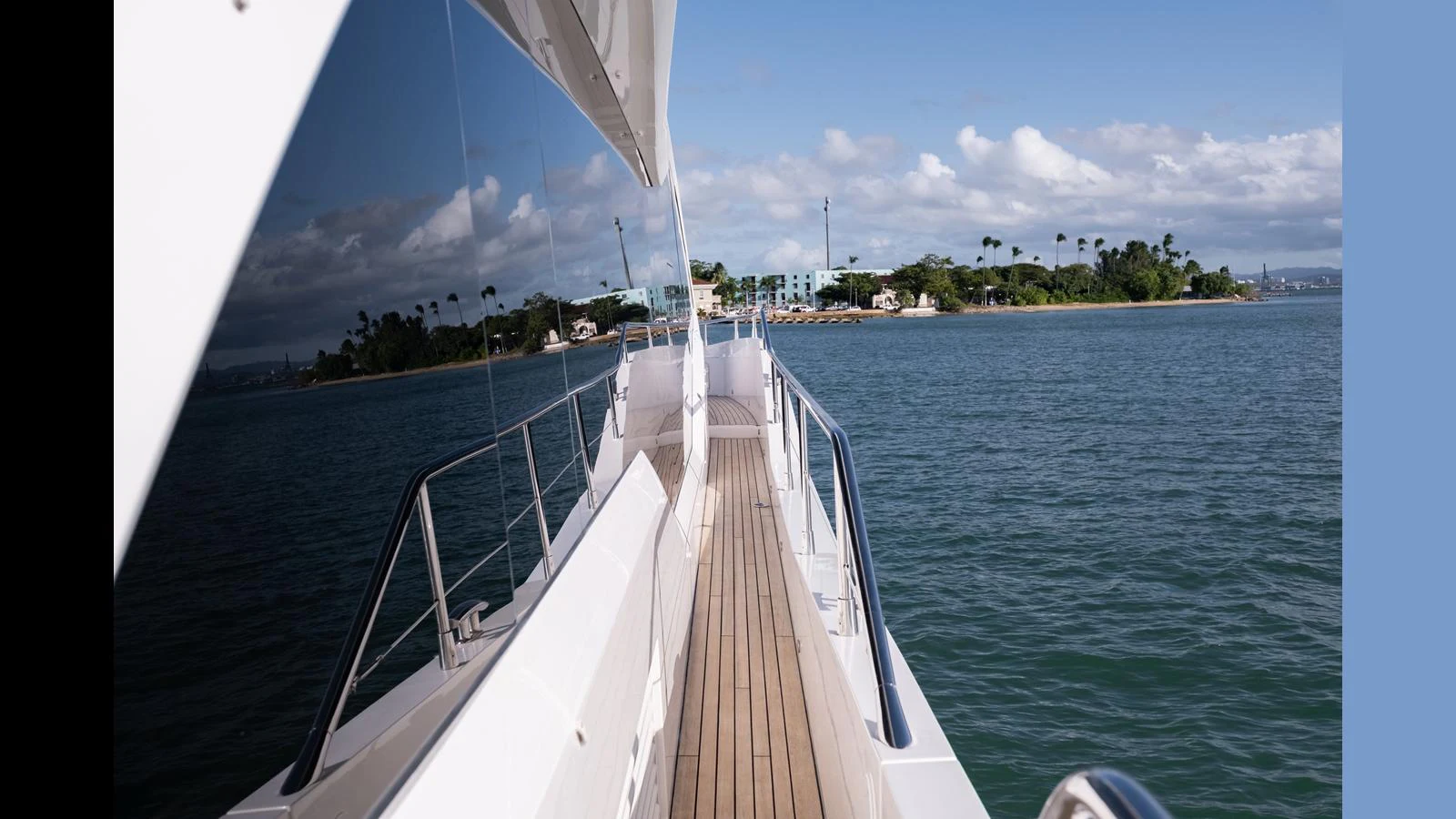 The side deck of the yacht offers a serene view of the surrounding waters and distant shoreline. aboard ONLY 1100 HRS! Yacht for Sale