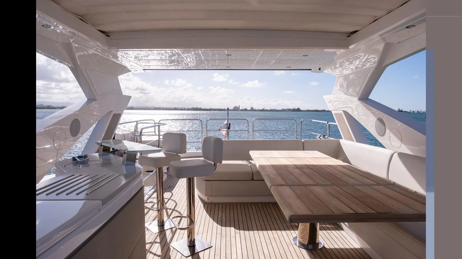 The aft deck offers a spacious and inviting area with a large dining table and bar stools, perfect for enjoying the view of the water. aboard ONLY 1100 HRS! Yacht for Sale