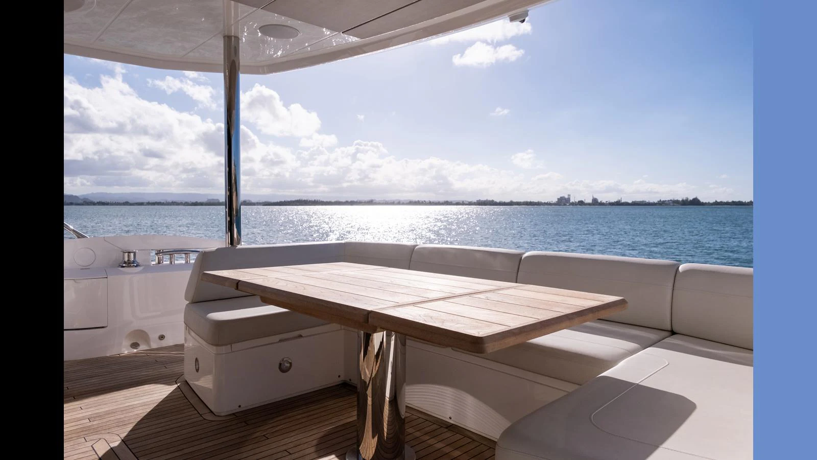 The aft deck features a stylish dining area with a wooden table and comfortable seating, offering stunning views of the water. aboard ONLY 1100 HRS! Yacht for Sale