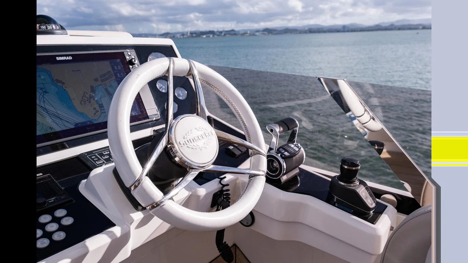 The helm station features a modern steering wheel and advanced navigation equipment with a scenic ocean backdrop. aboard ONLY 1100 HRS! Yacht for Sale