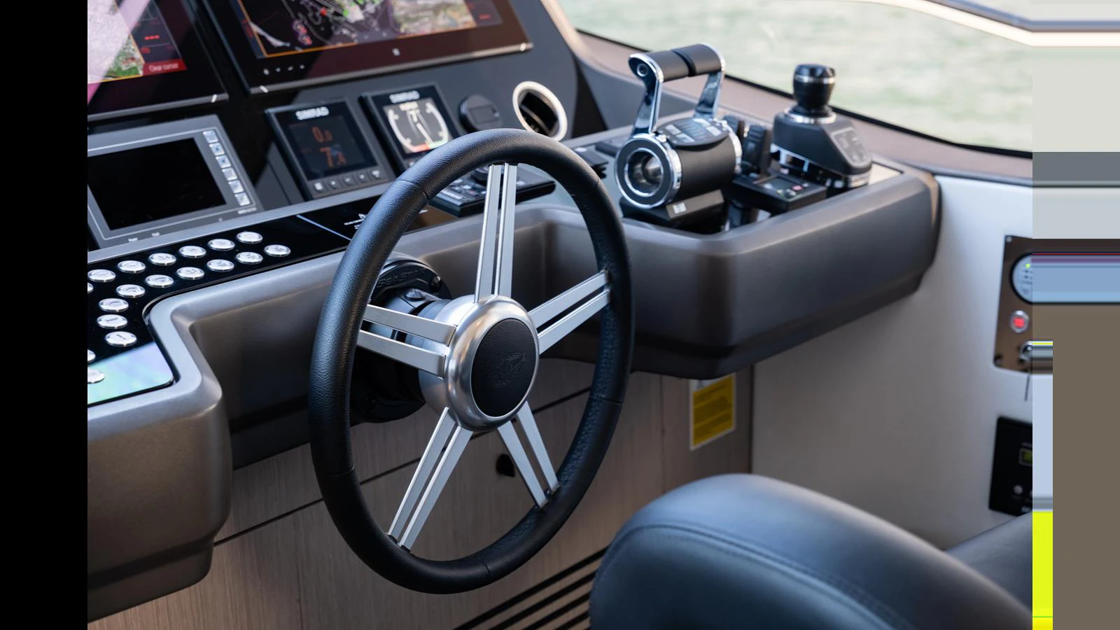 The helm station features a modern steering wheel and advanced navigation controls. aboard ONLY 1100 HRS! Yacht for Sale