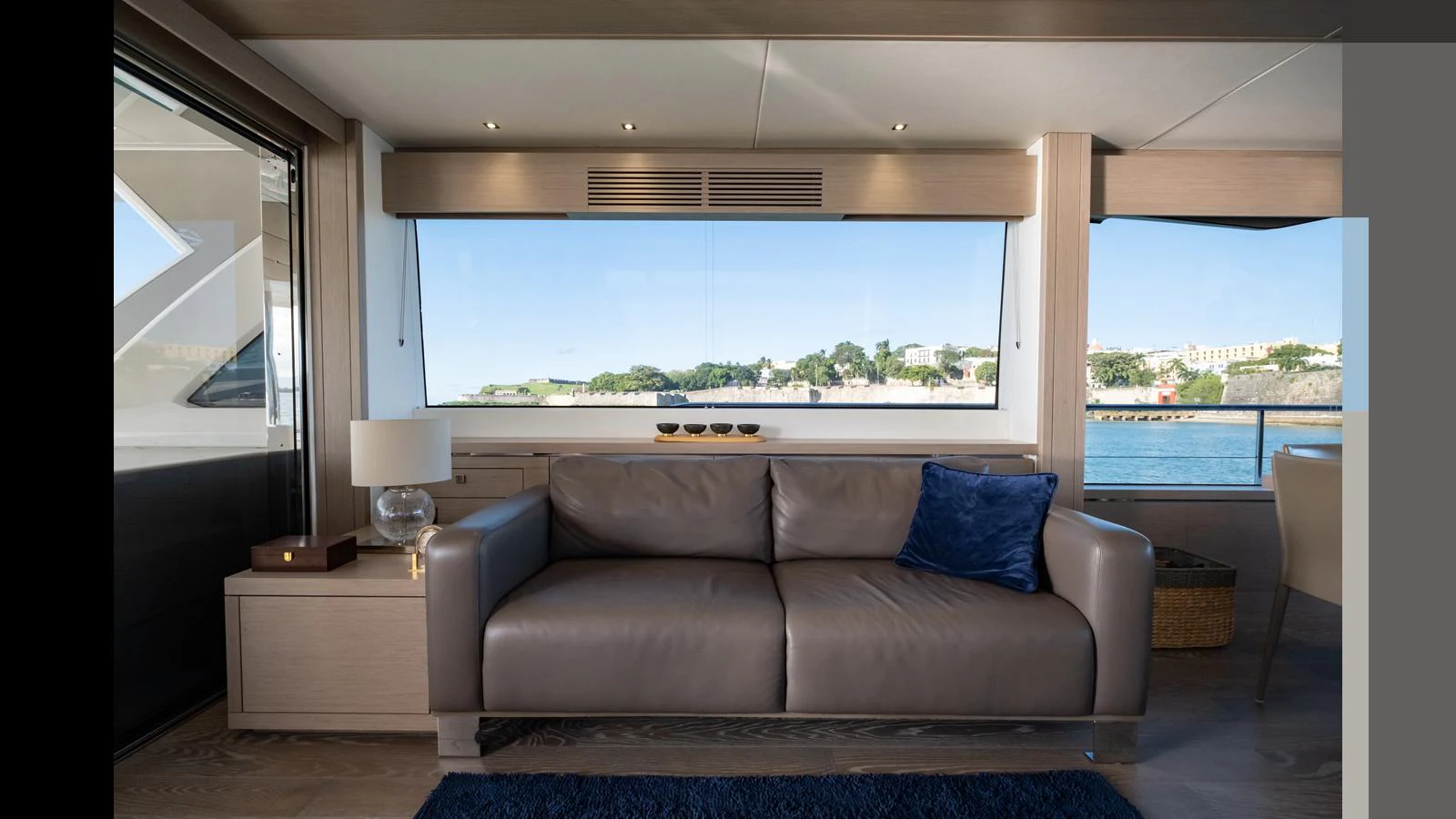 The salon features a comfortable leather sofa with a large window offering scenic views. aboard ONLY 1100 HRS! Yacht for Sale
