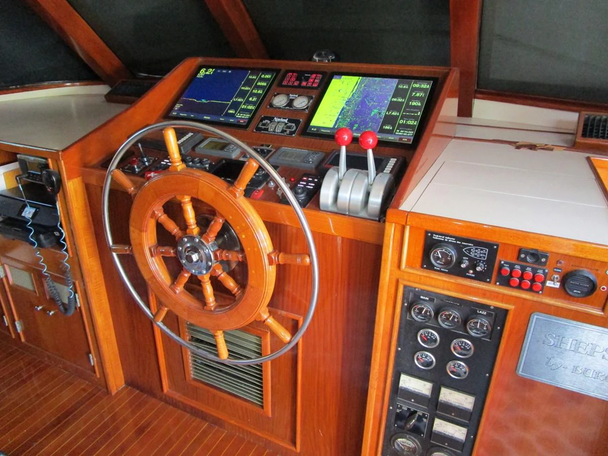 The helm station features classic wooden finishes and modern navigation equipment. aboard SHEPSL X Yacht for Sale