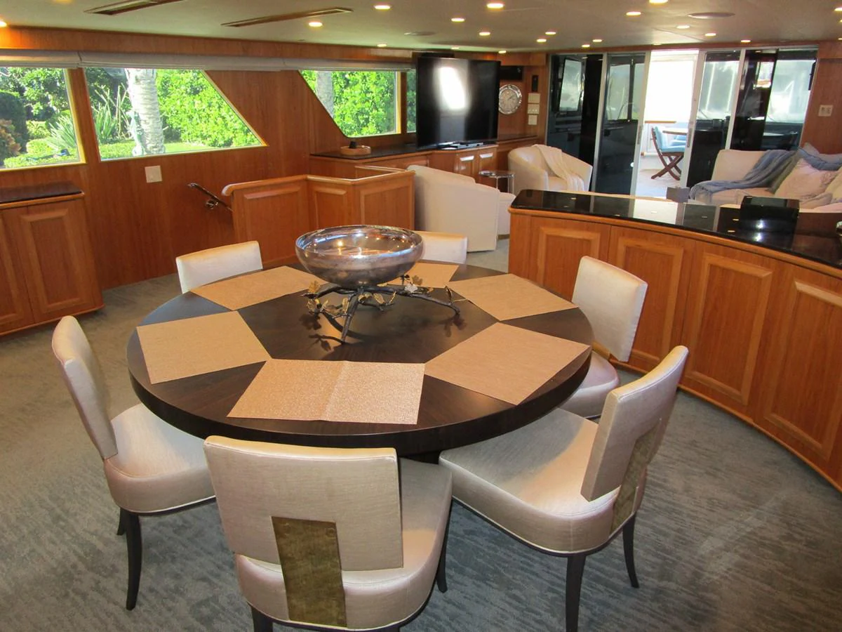 The yacht's dining area features a stylish round table with comfortable seating and elegant decor. aboard SHEPSL X Yacht for Sale