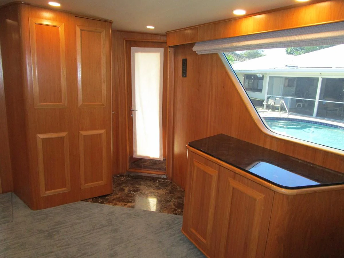 The yacht's interior features a wooden finish with a large window offering a view of the outside. aboard SHEPSL X Yacht for Sale