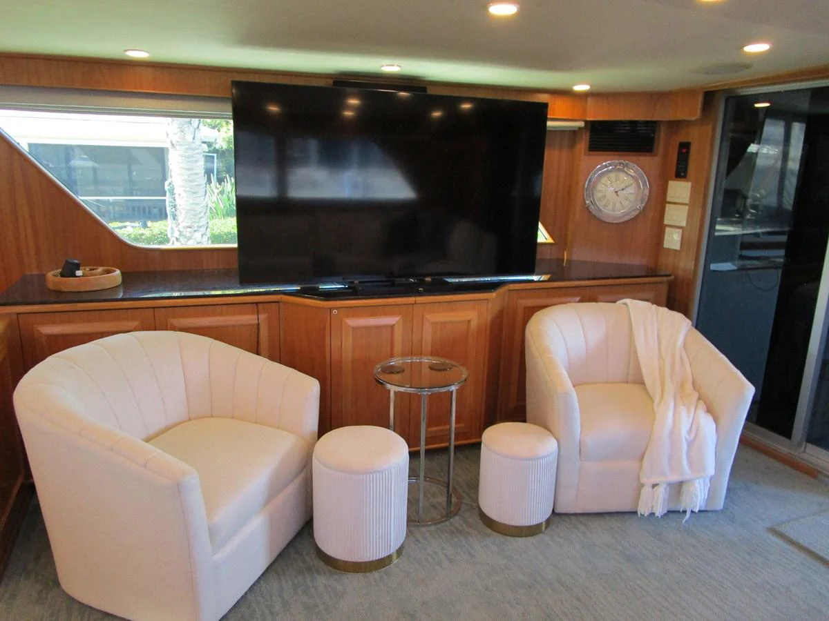 A cozy interior lounge area featuring comfortable seating and a large flat-screen TV. aboard SHEPSL X Yacht for Sale