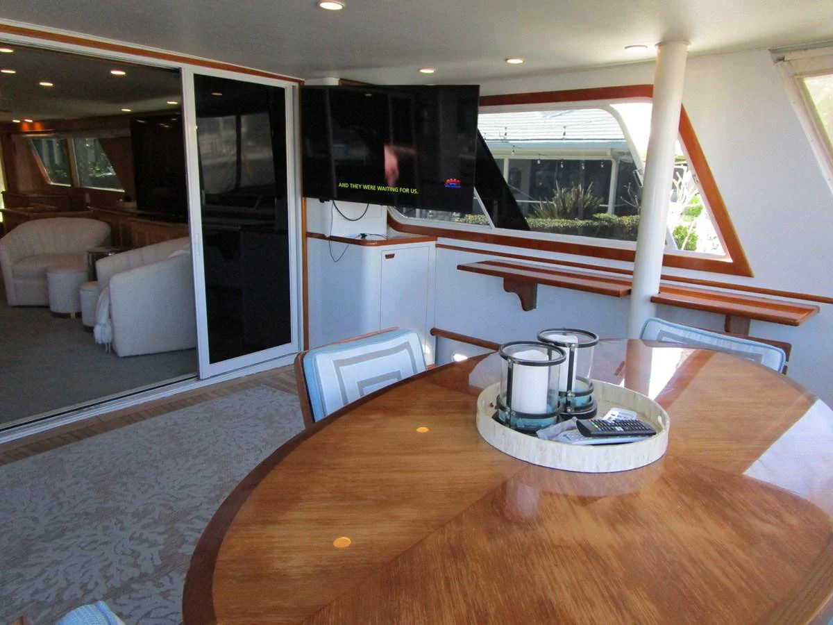 The salon features a comfortable seating area with a large wooden table and modern amenities. aboard SHEPSL X Yacht for Sale