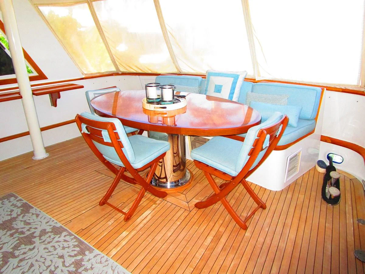 The yacht's dining area features a polished wooden table surrounded by comfortable seating, perfect for intimate meals. aboard SHEPSL X Yacht for Sale