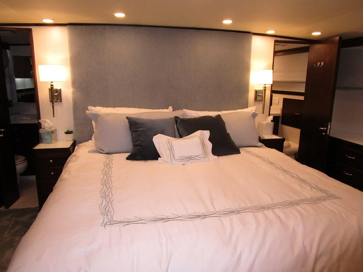 The master stateroom features a luxurious bed with elegant bedding and ambient lighting. aboard SHEPSL X Yacht for Sale