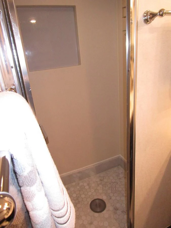 A compact and functional yacht bathroom with a modern shower area. aboard SHEPSL X Yacht for Sale