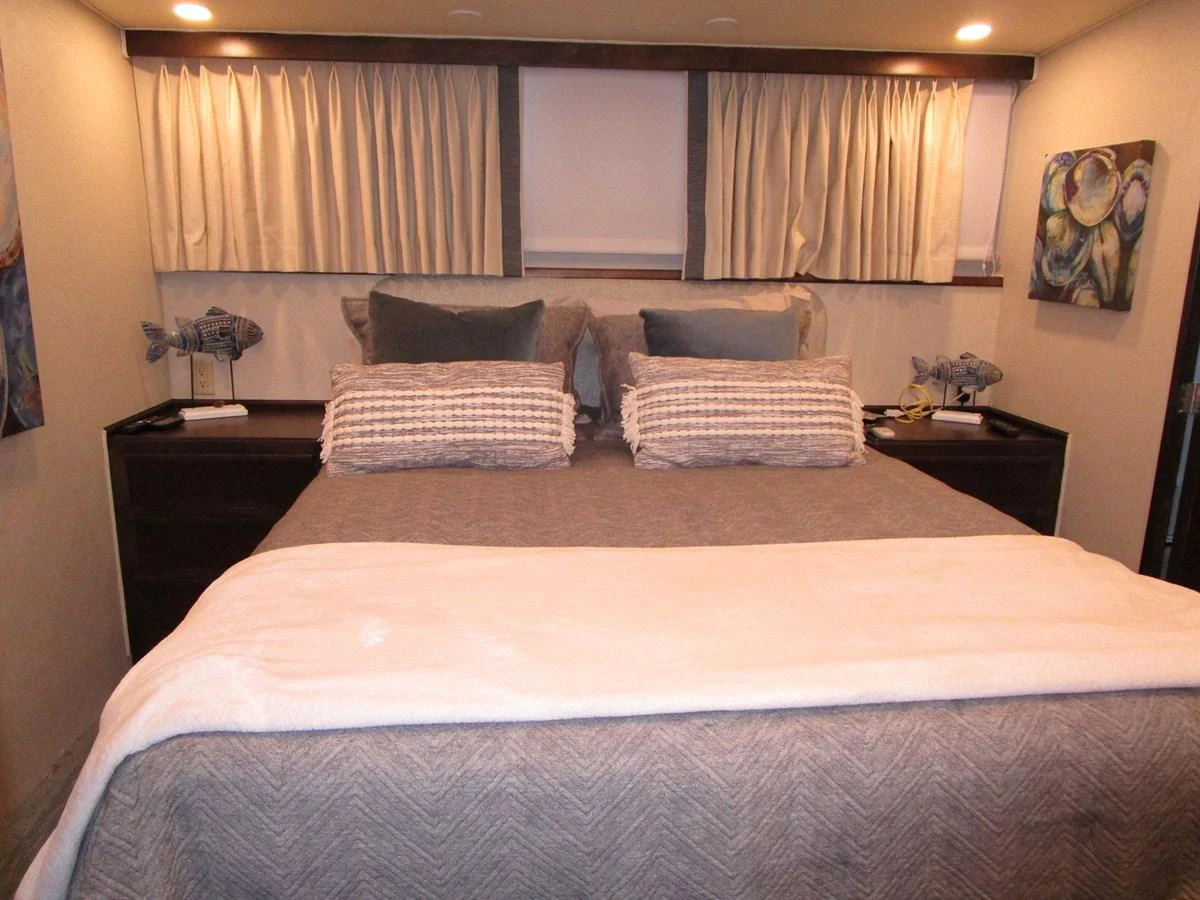 A cozy stateroom featuring a comfortable bed with plush pillows and soft lighting. aboard SHEPSL X Yacht for Sale