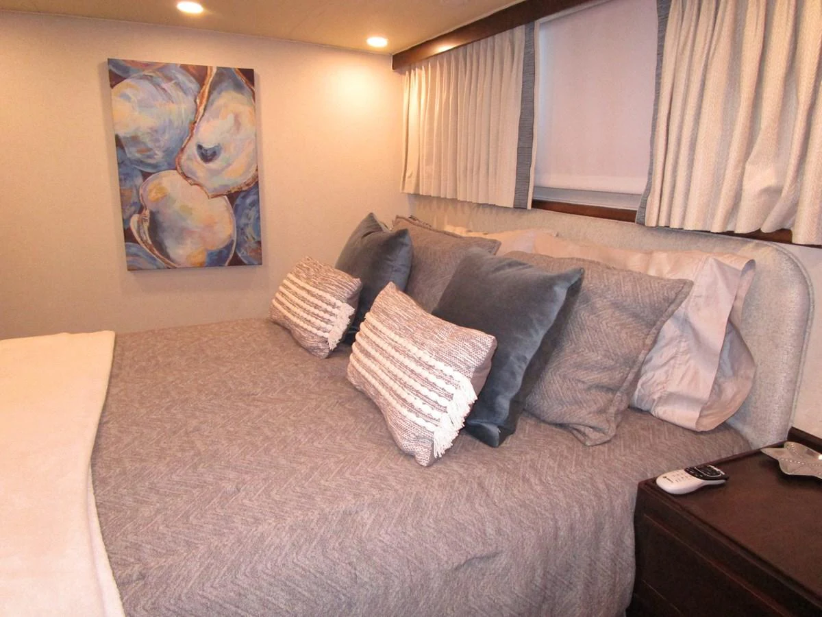 The stateroom features a cozy bed with plush pillows and soft lighting, creating a serene retreat. aboard SHEPSL X Yacht for Sale