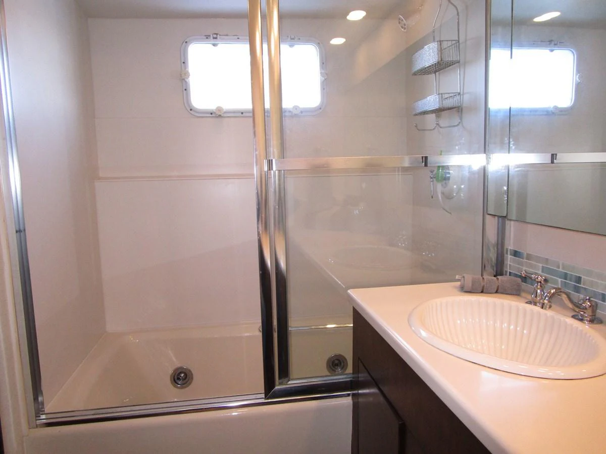 The yacht's bathroom features a sleek design with a glass-enclosed shower and a modern sink. aboard SHEPSL X Yacht for Sale