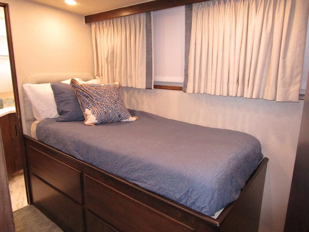 A cozy stateroom with a single bed, elegant bedding, and ample storage space. aboard SHEPSL X Yacht for Sale