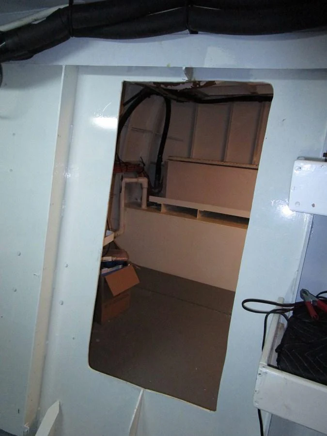 A view of a utility or storage area within the yacht, featuring exposed structural elements and some stored items. aboard SHEPSL X Yacht for Sale