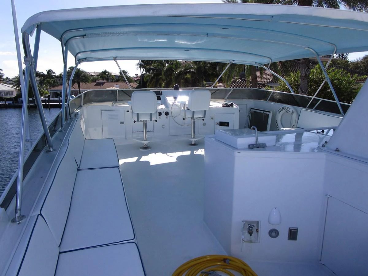 The flybridge offers a spacious and shaded area with comfortable seating and helm controls. aboard SHEPSL X Yacht for Sale