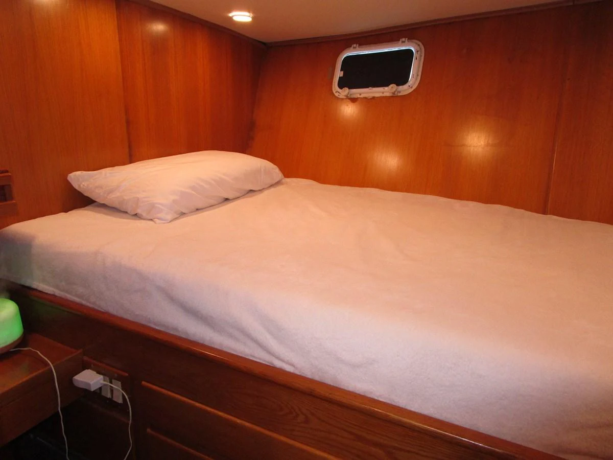 A cozy stateroom with a single bed and wooden paneling. aboard SHEPSL X Yacht for Sale