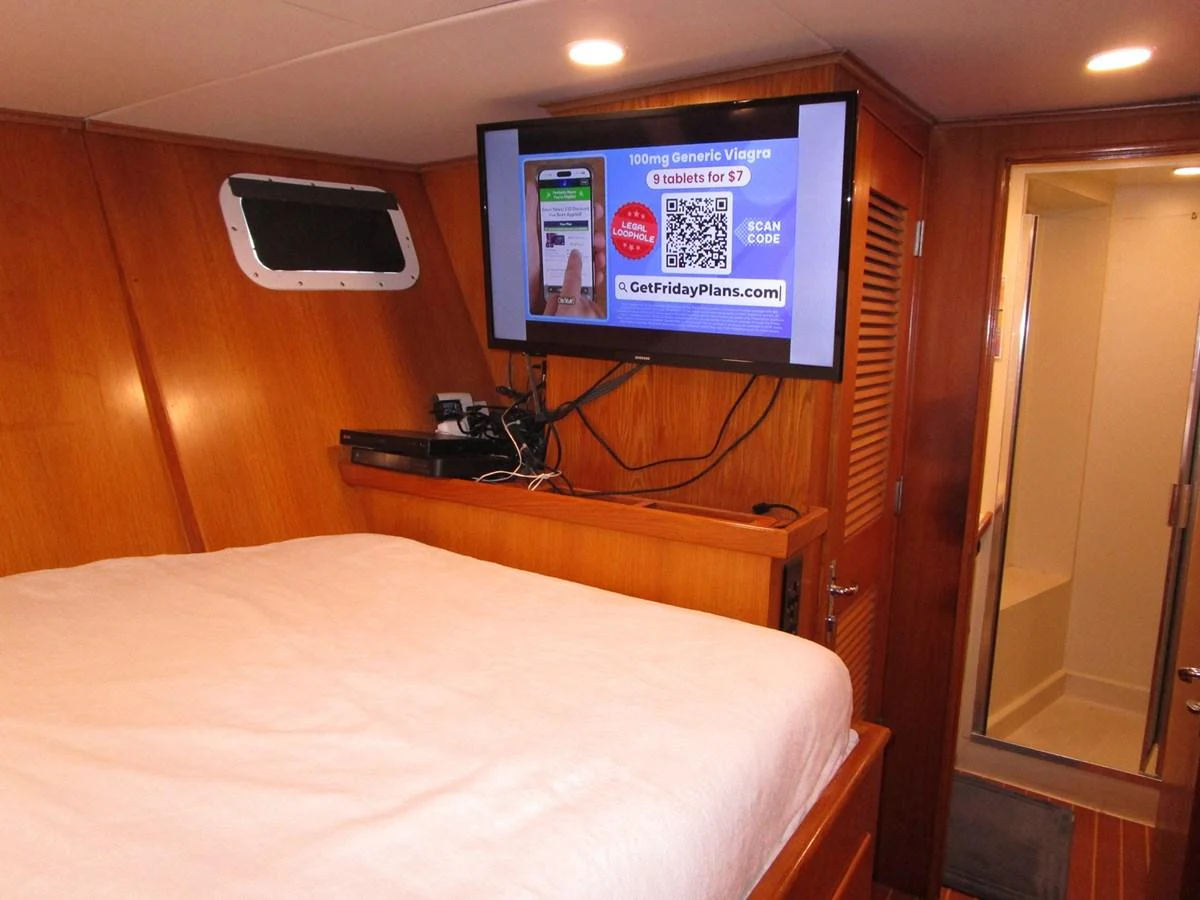A cozy stateroom featuring a comfortable bed and a wall-mounted television. aboard SHEPSL X Yacht for Sale
