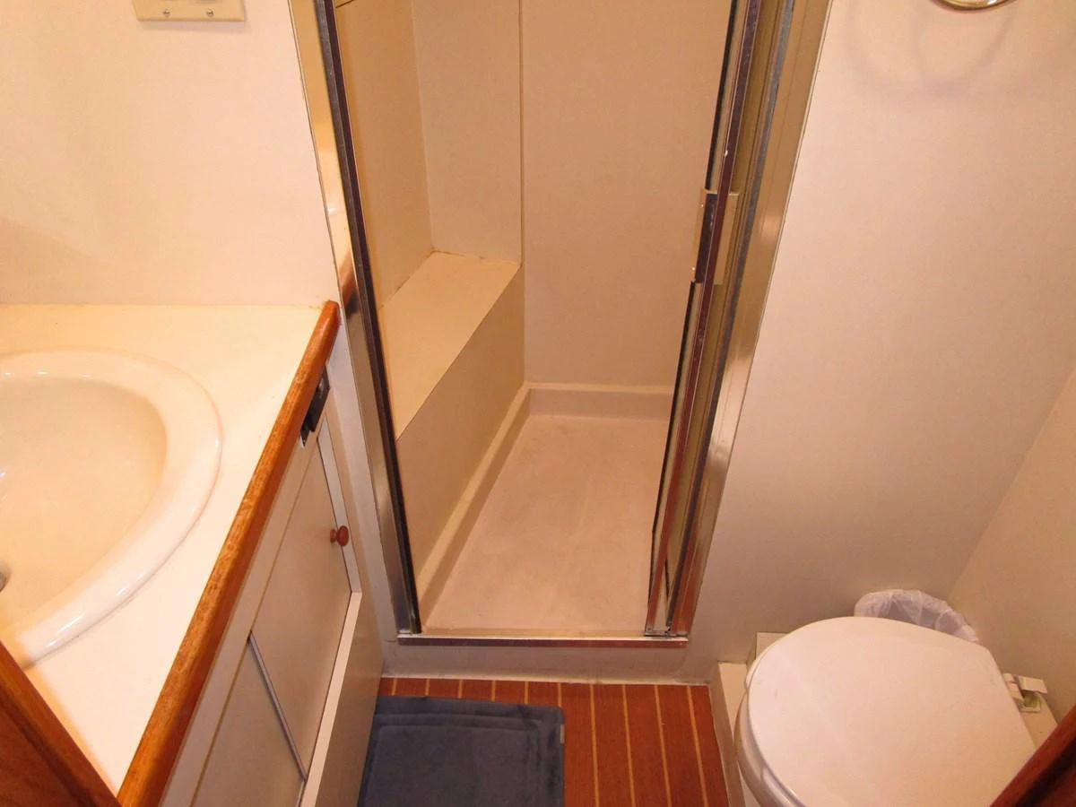 The yacht's bathroom features a compact shower, sink, and toilet with practical design. aboard SHEPSL X Yacht for Sale