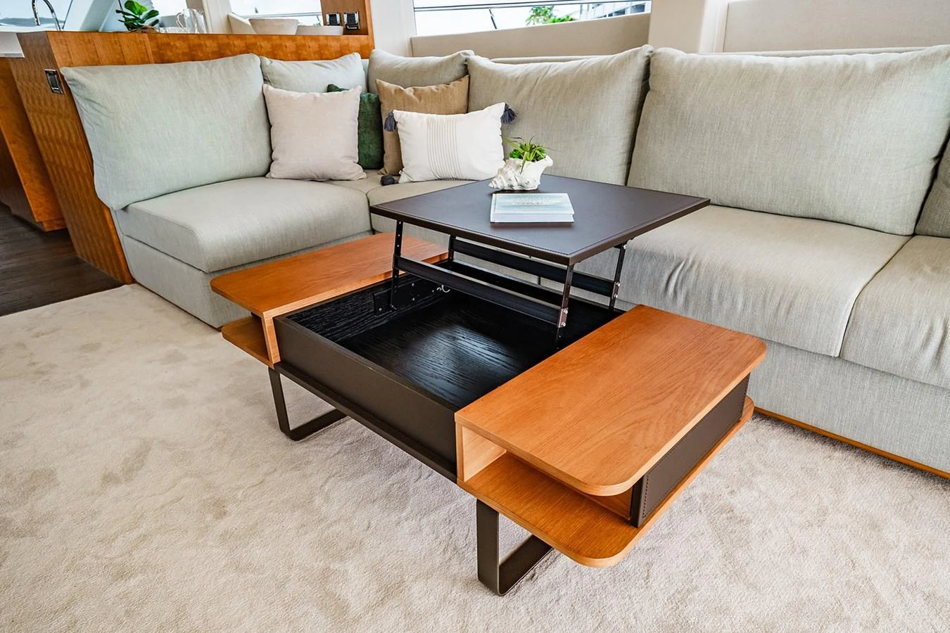 The salon features a stylish coffee table with a lift-top mechanism, surrounded by plush seating. aboard INDIGO Yacht for Sale