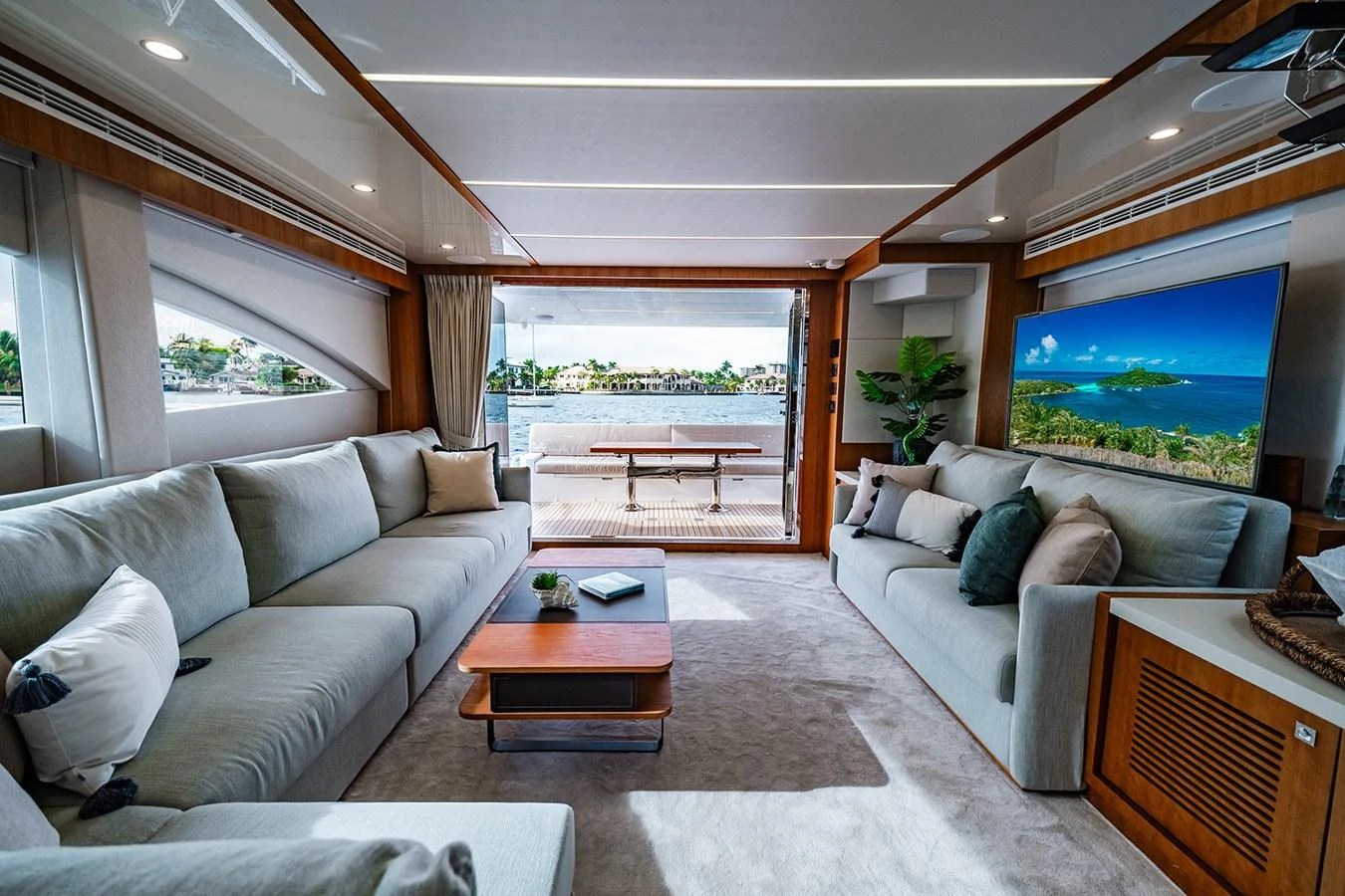 The salon offers a spacious and luxurious seating area with a view of the water through large windows. aboard INDIGO Yacht for Sale