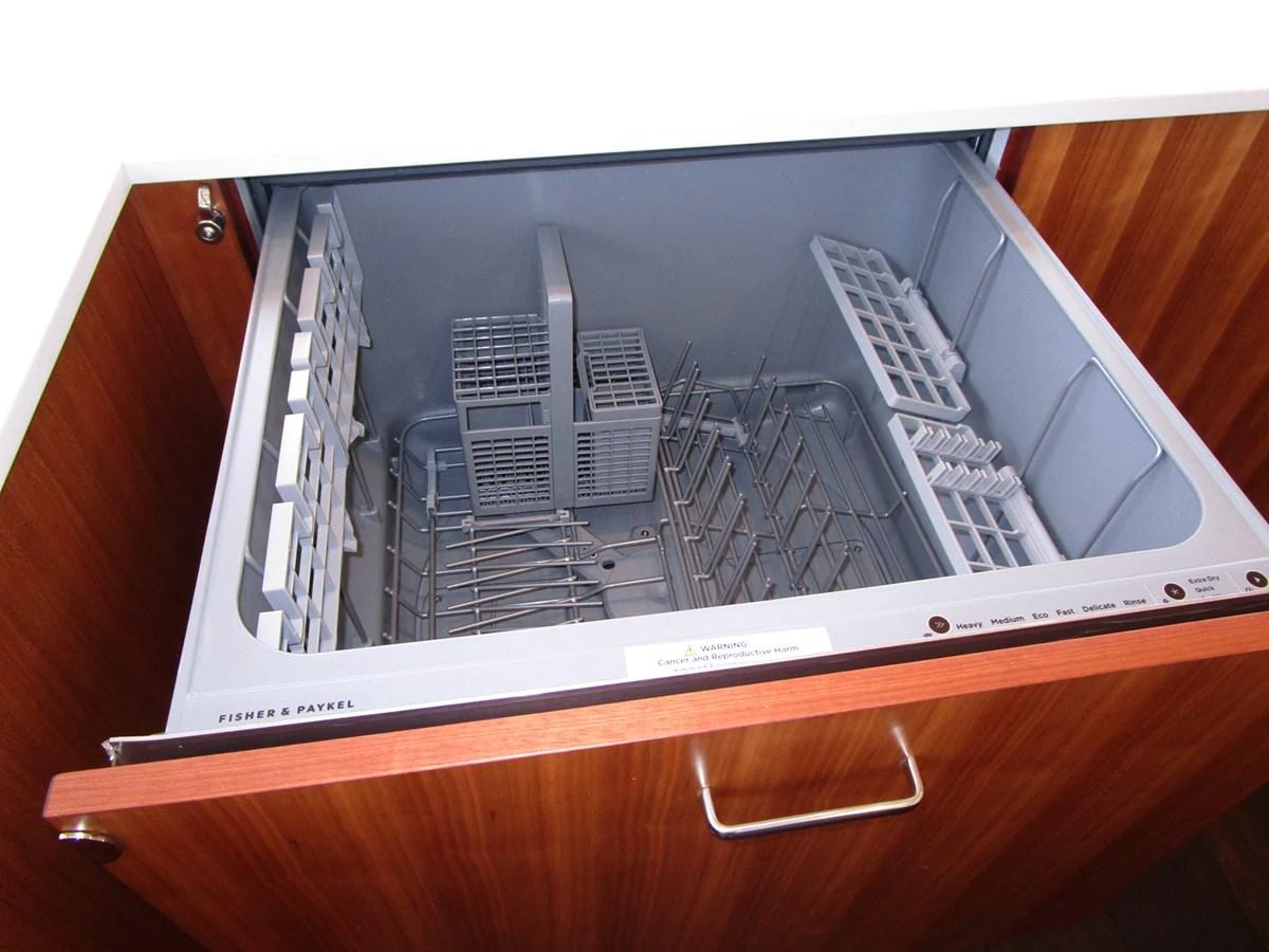 The image showcases a built-in dishwasher drawer in the yacht's galley. aboard INDIGO Yacht for Sale